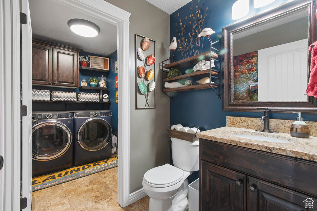 Bathroom with washer and dryer, toilet, and vanity