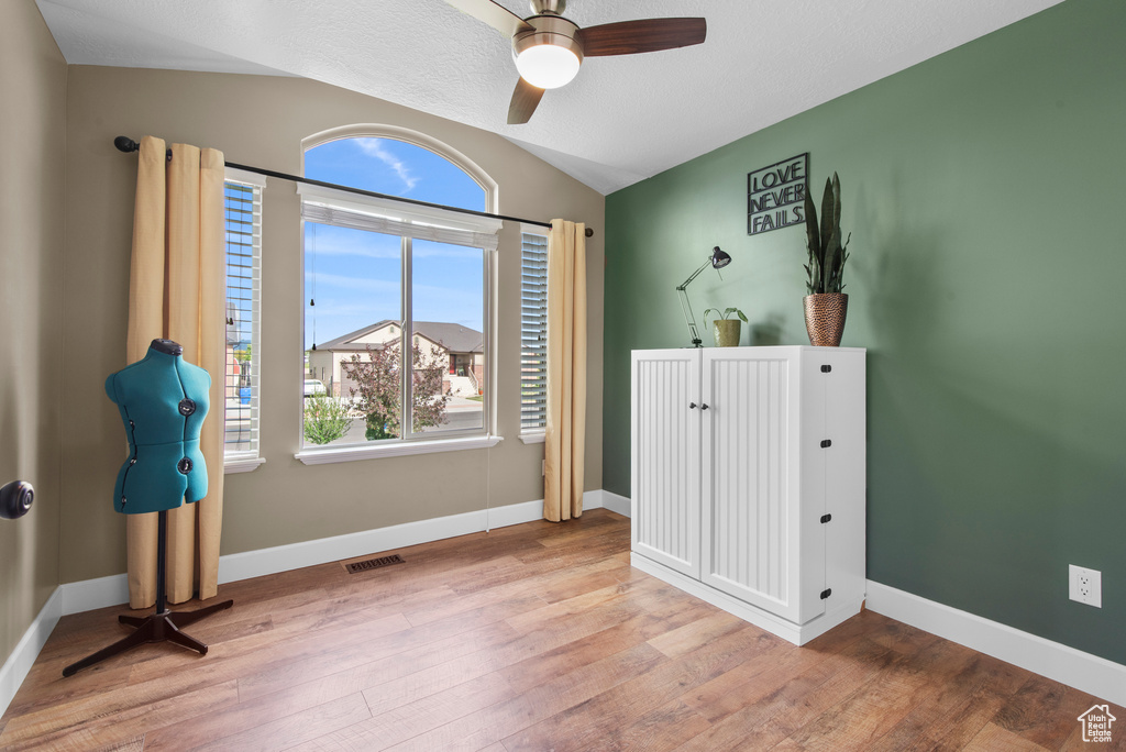 Unfurnished bedroom featuring vaulted ceiling, wood finished floors, baseboards, and ceiling fan