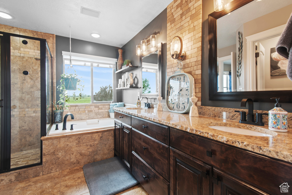 Full bathroom with a stall shower, a bath, double vanity, and tile patterned floors