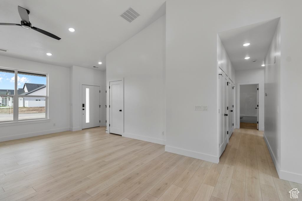 Unfurnished living room with a ceiling fan, light wood finished floors, baseboards, and recessed lighting