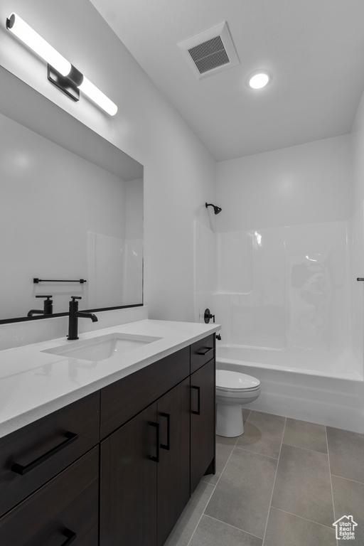 Bathroom featuring vanity, shower / bathtub combination, toilet, and tile patterned floors