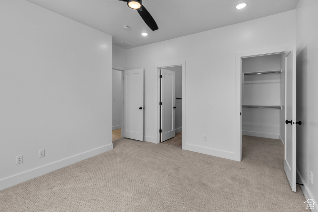 Unfurnished bedroom featuring carpet floors, a walk in closet, recessed lighting, and baseboards