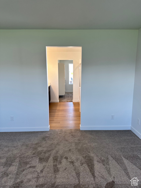 Carpeted spare room featuring baseboards