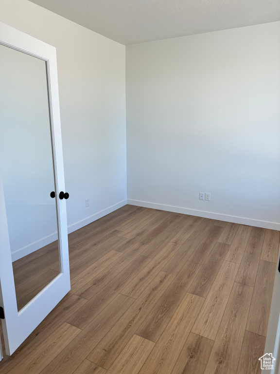 Unfurnished room with wood finished floors and baseboards