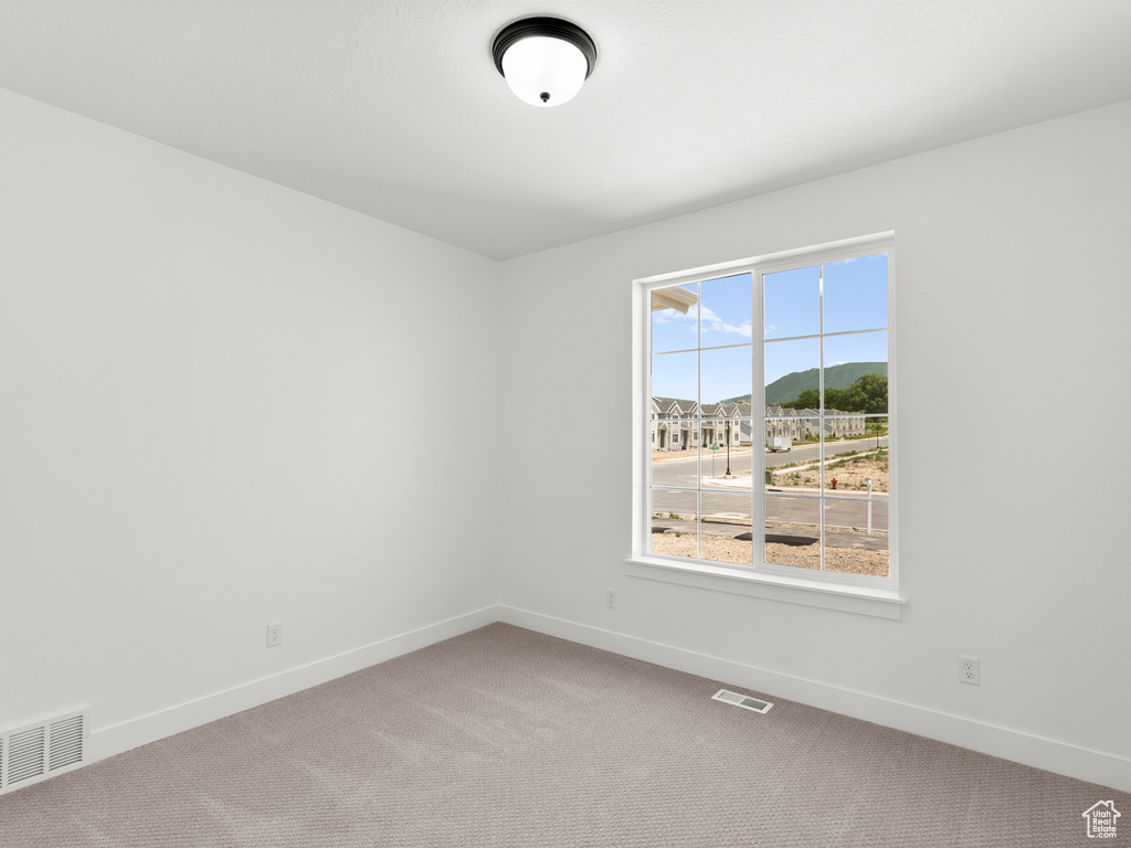 Empty room featuring carpet flooring and baseboards