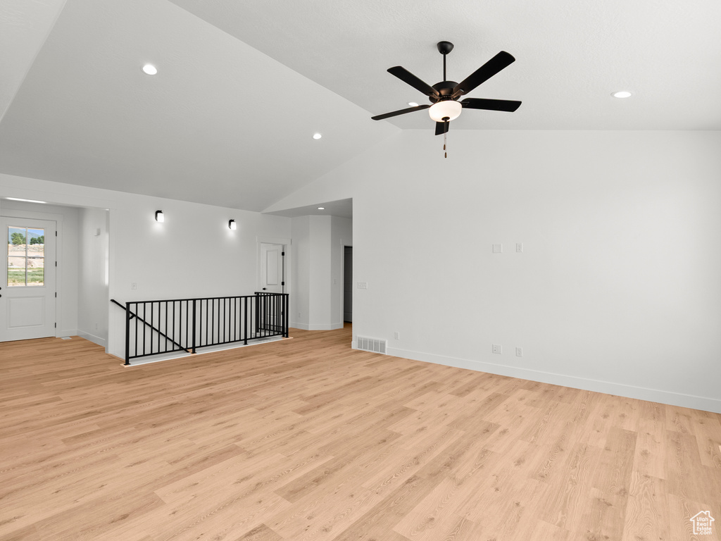 Empty room featuring vaulted ceiling, light wood-style flooring, a ceiling fan, and recessed lighting