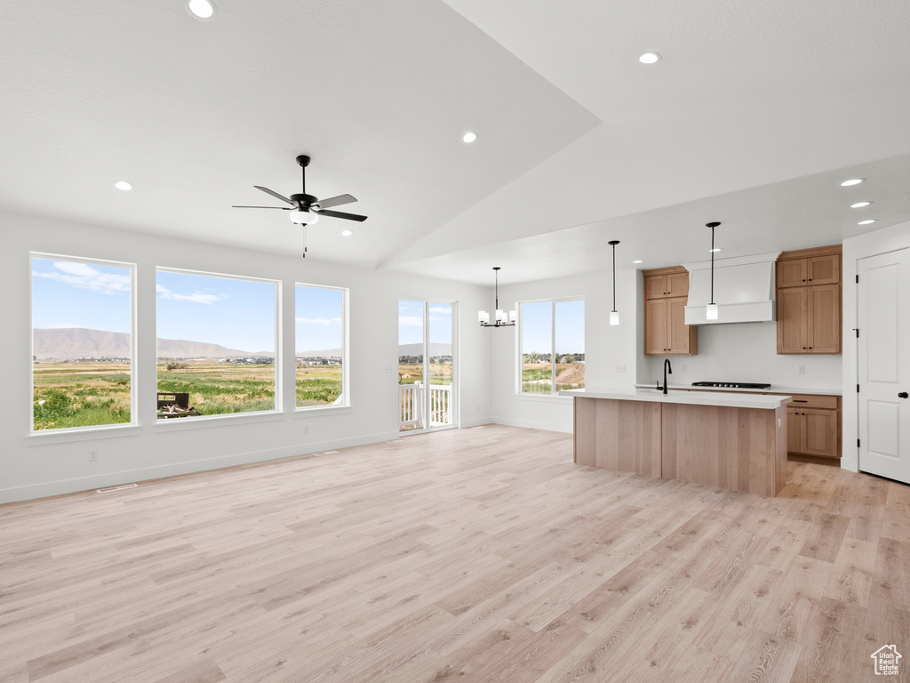 Kitchen featuring open floor plan, light countertops, light wood-type flooring, ceiling fan, and stovetop