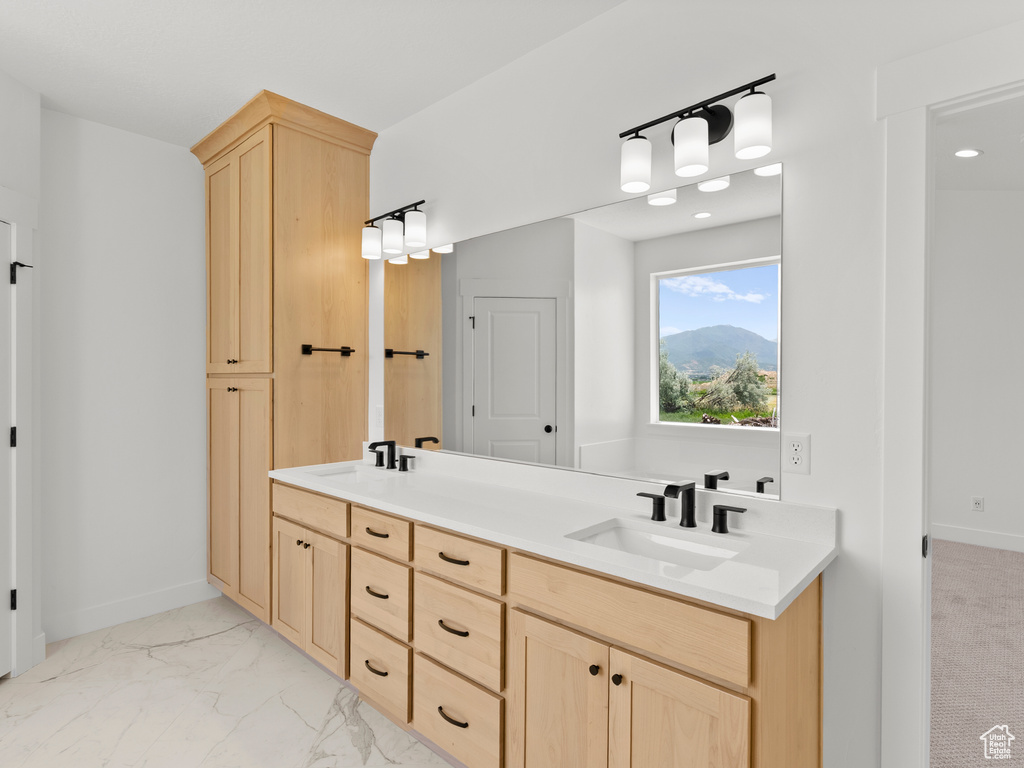 Full bath with double vanity, marble finish floors, and recessed lighting