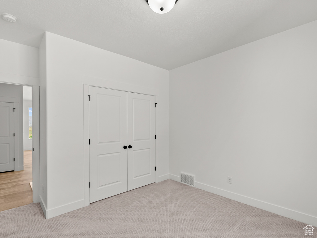 Unfurnished bedroom with carpet flooring and a closet