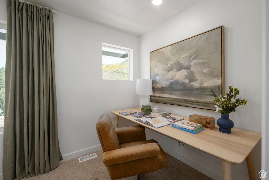 Carpeted home office featuring baseboards