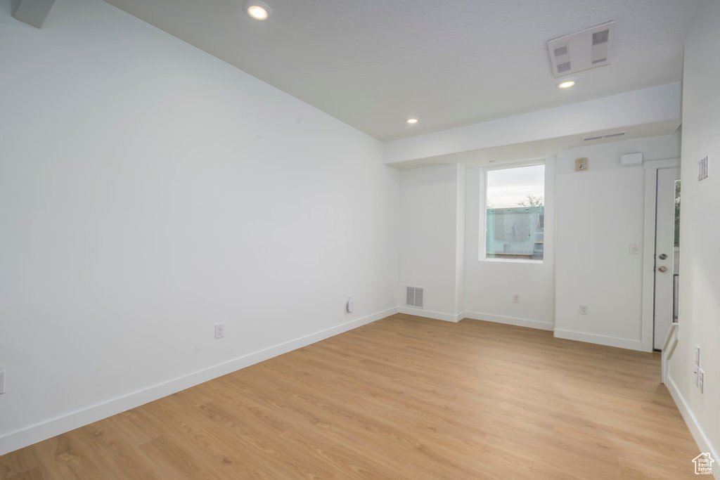 Unfurnished room featuring light wood finished floors, recessed lighting, and baseboards