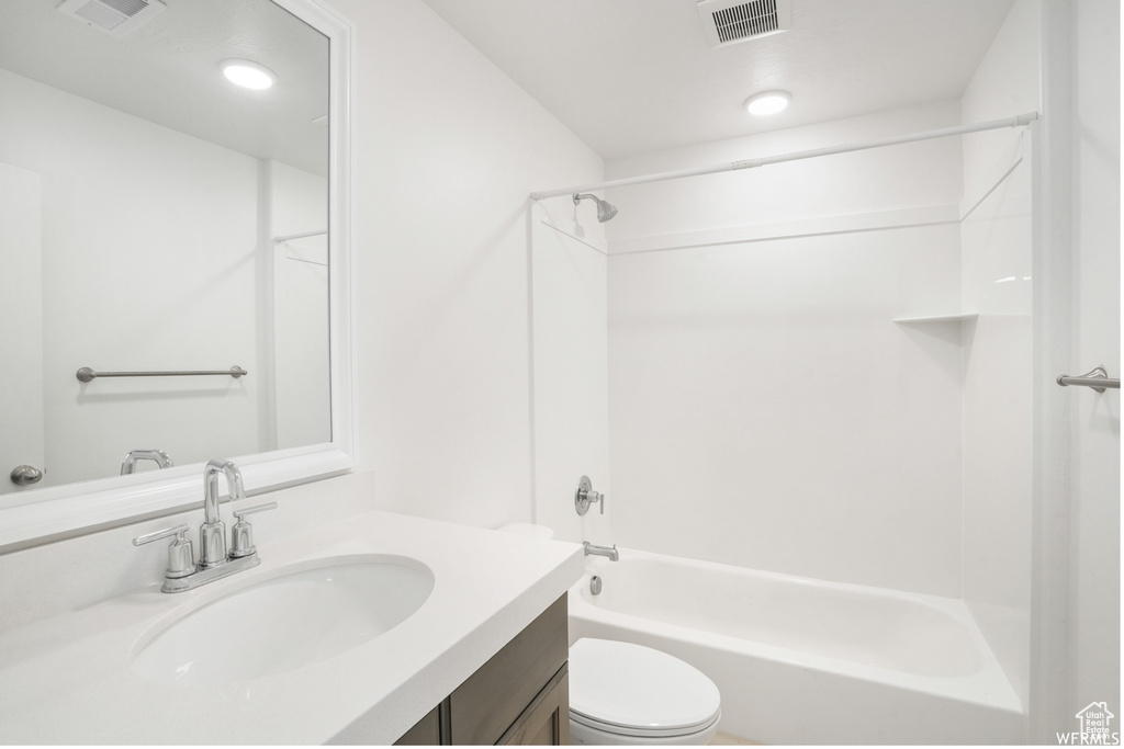 Bathroom featuring toilet, tub / shower combination, and vanity