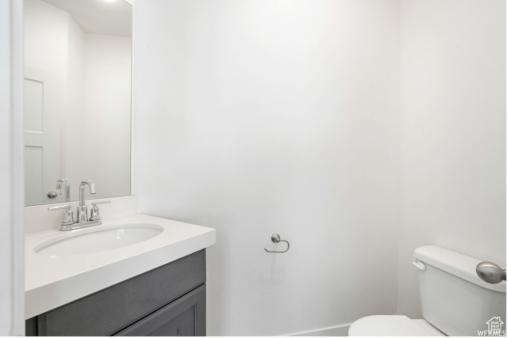 Half bathroom featuring toilet and vanity