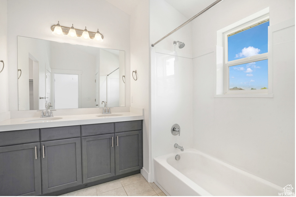Bathroom featuring bathing tub / shower combination, double vanity, and tile patterned floors