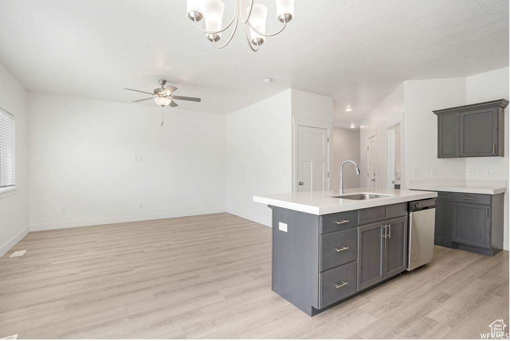 Kitchen featuring a sink, dishwasher, light wood-style flooring, and light countertops
