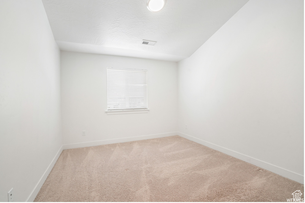Carpeted empty room with baseboards