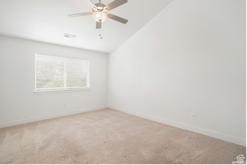 Spare room with light carpet, baseboards, and ceiling fan