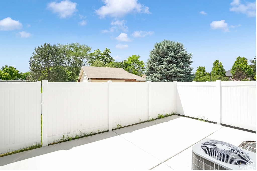 View of patio featuring central AC unit and fence