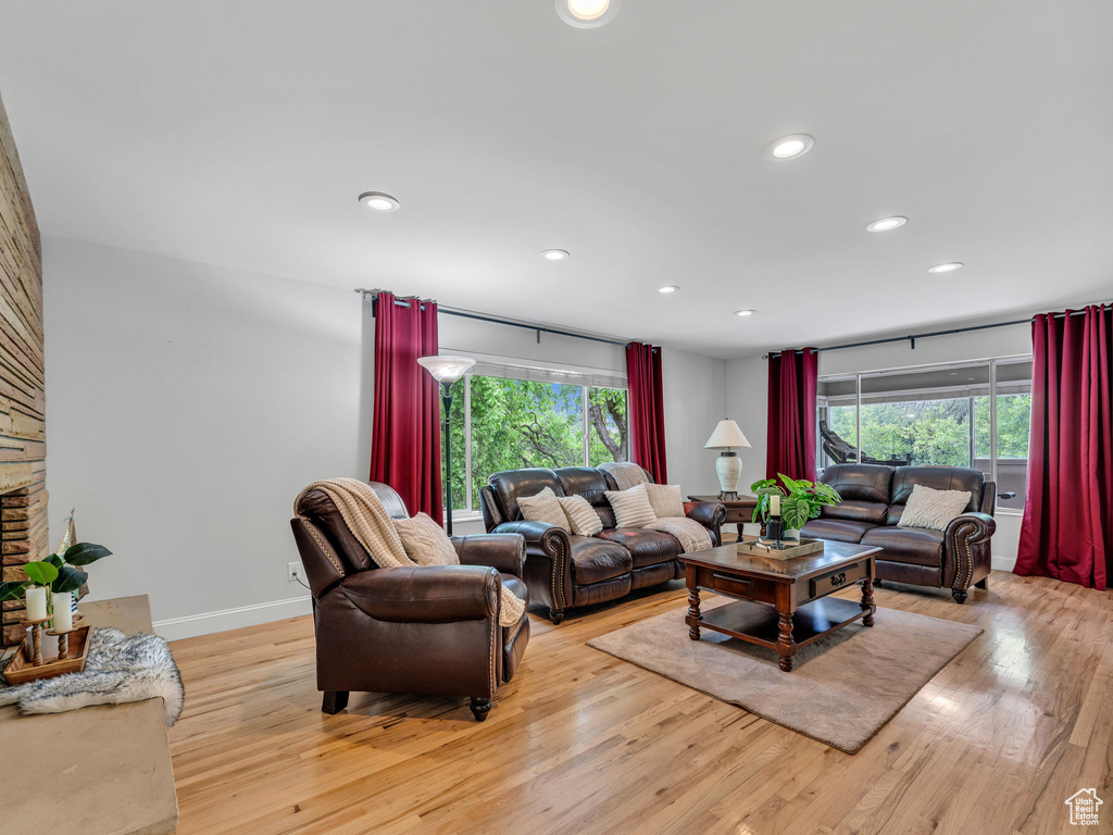 Living room with light wood finished floors, plenty of natural light, recessed lighting, and baseboards