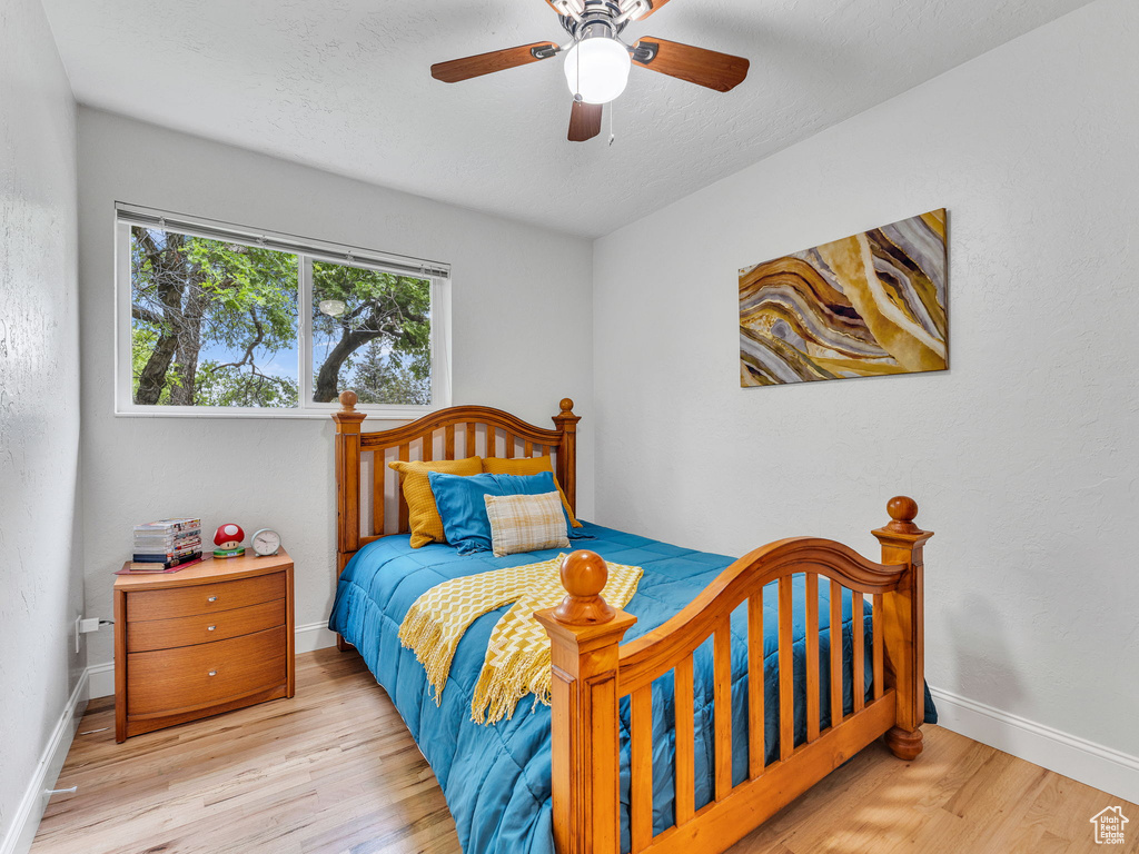 Bedroom featuring wood finished floors, baseboards, and a ceiling fan
