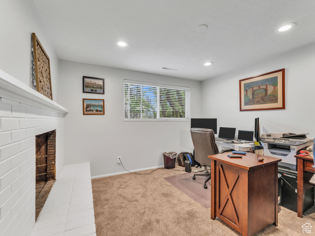 Office space featuring light carpet, recessed lighting, a fireplace, and baseboards