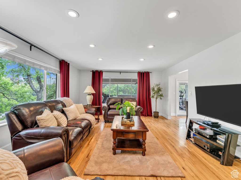 Living room with recessed lighting, light wood finished floors, healthy amount of natural light, and baseboards