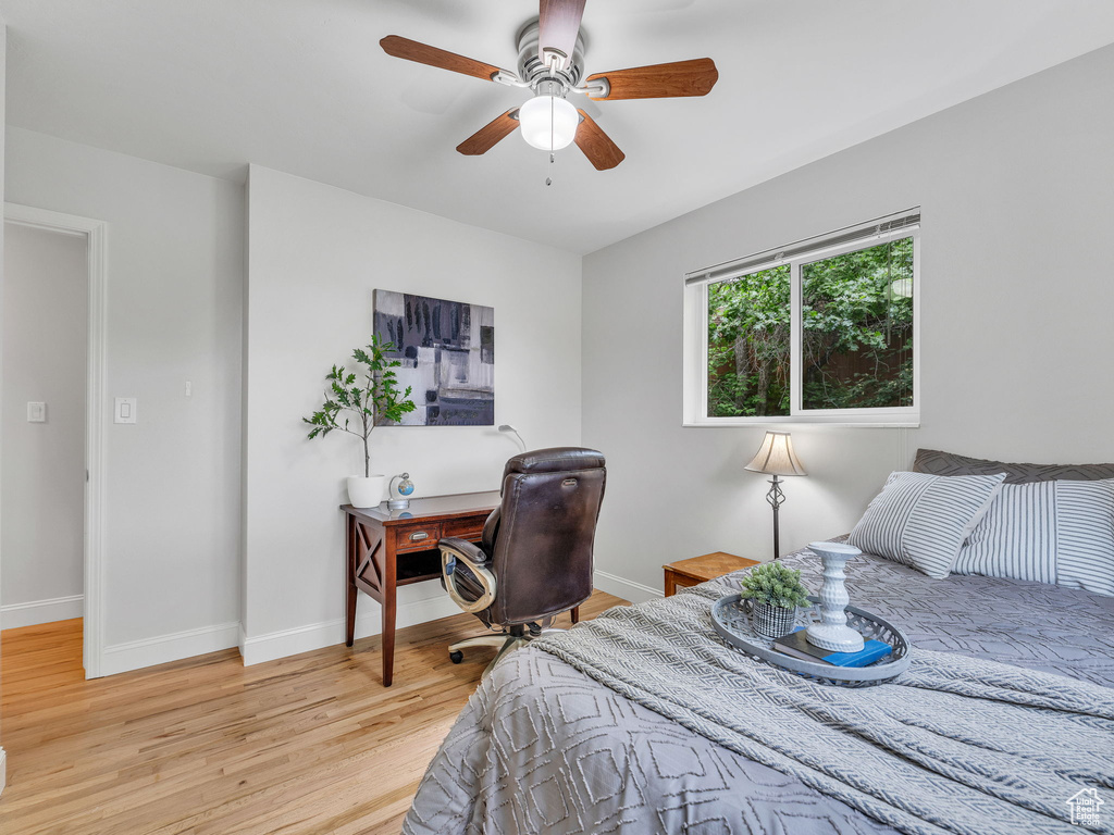 Bedroom with light wood finished floors, baseboards, and ceiling fan