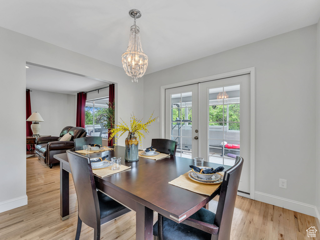 Dining area featuring healthy amount of natural light, french doors, baseboards, and a chandelier