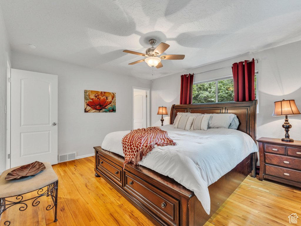 Bedroom with light wood-style flooring, baseboards, and ceiling fan