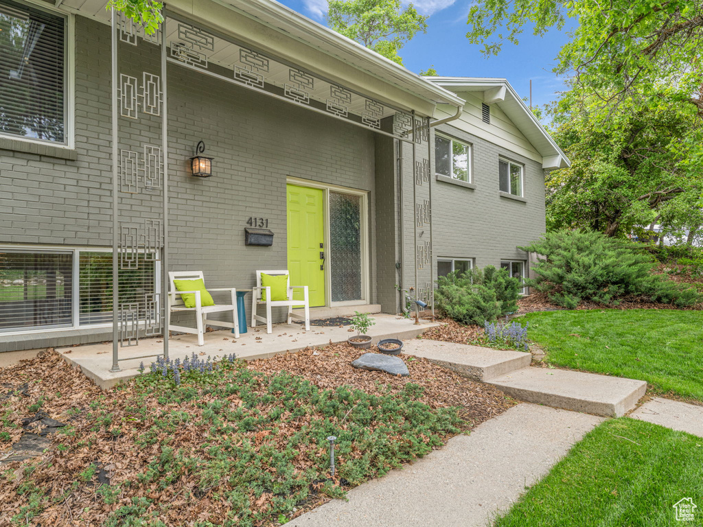 Property entrance with brick siding and a lawn