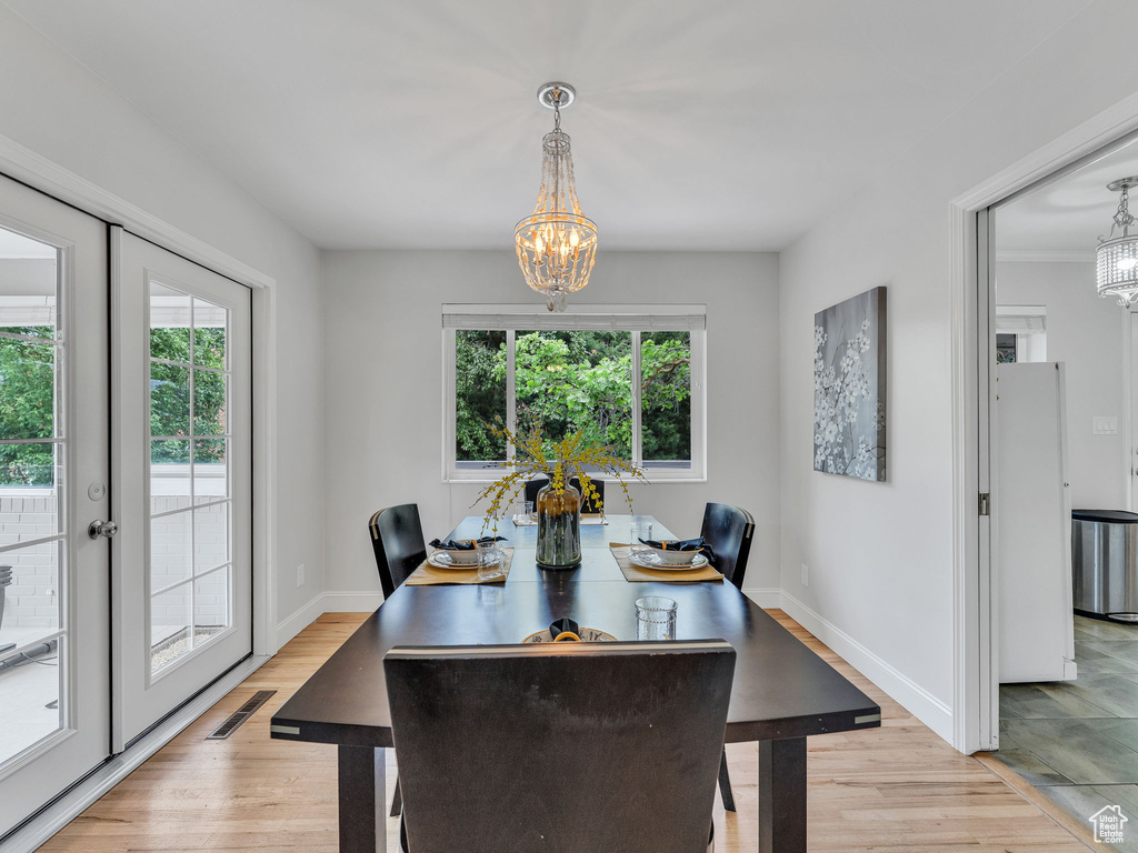 Dining area featuring a chandelier, baseboards, and light wood-style floors