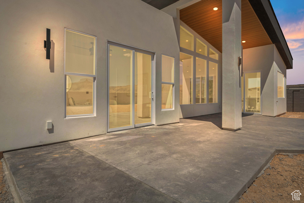 Back of house with stucco siding and a patio area
