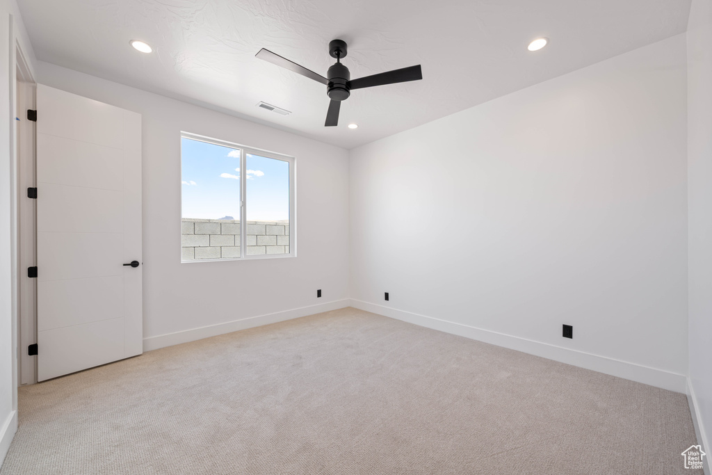 Spare room featuring ceiling fan, light carpet, recessed lighting, and baseboards