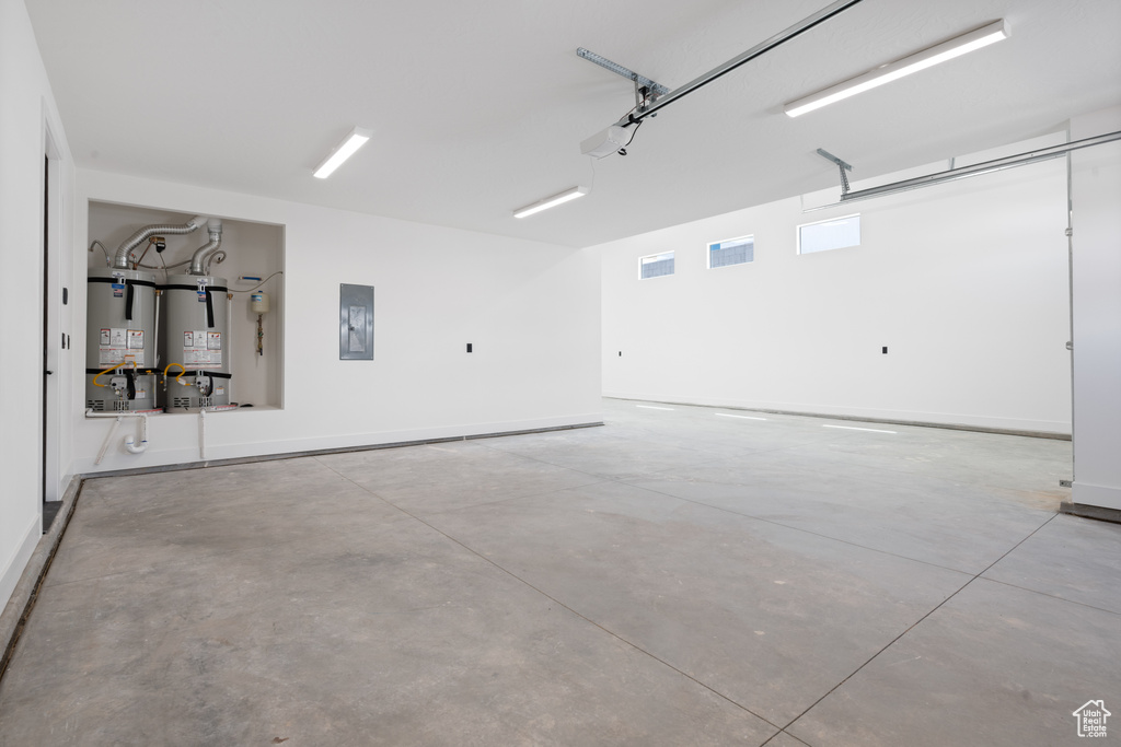 Garage with secured water heater, electric panel, and baseboards