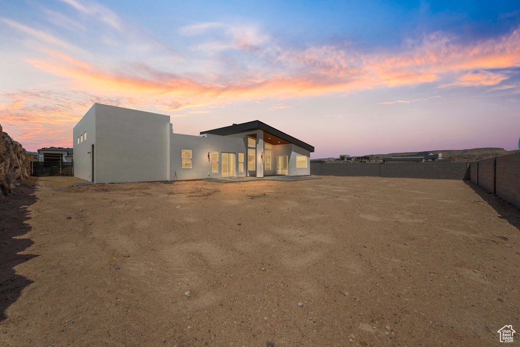 Rear view of property featuring a fenced backyard and stucco siding