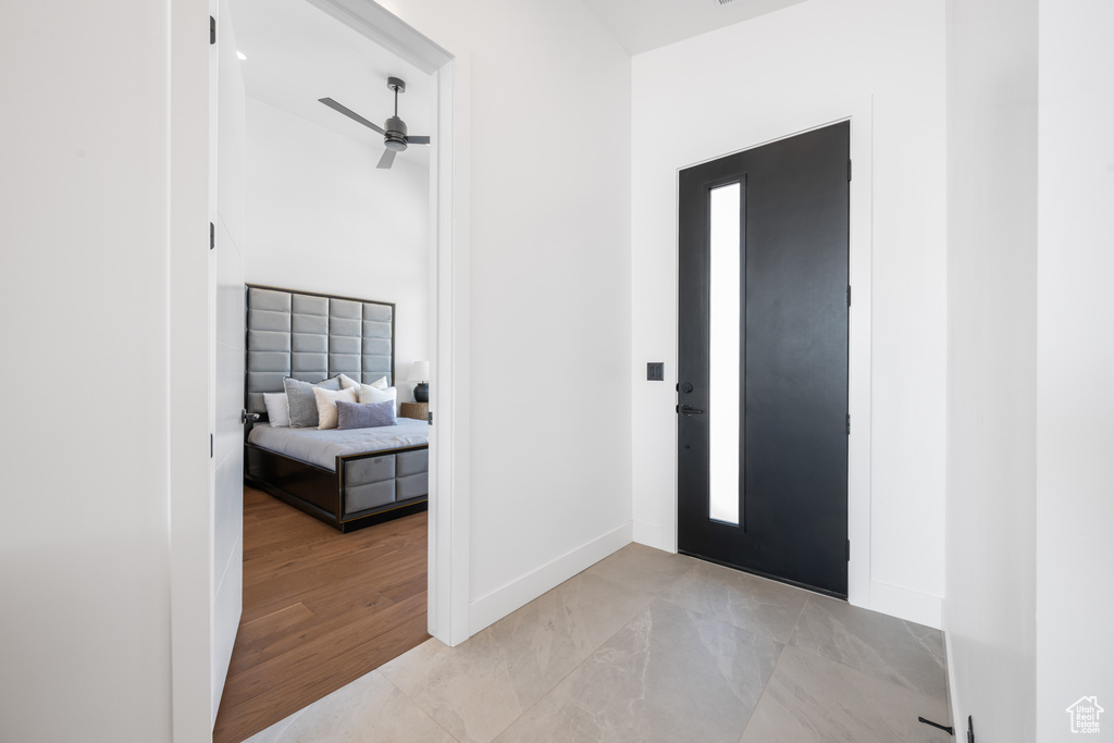 Foyer featuring baseboards, light marble finish flooring, and a ceiling fan