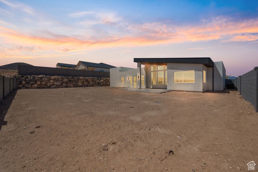 Back of house featuring a fenced backyard and stucco siding