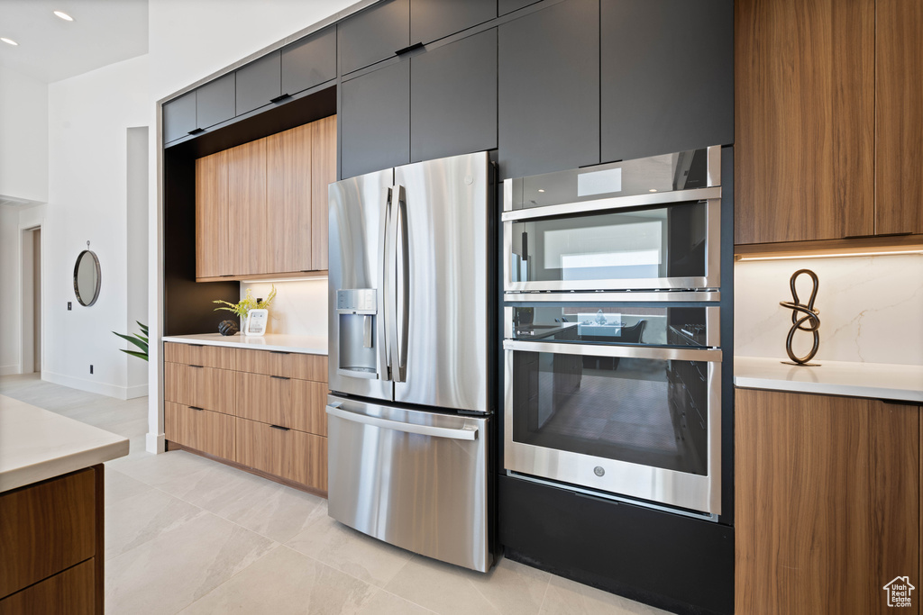 Kitchen with appliances with stainless steel finishes, light countertops, and modern cabinets