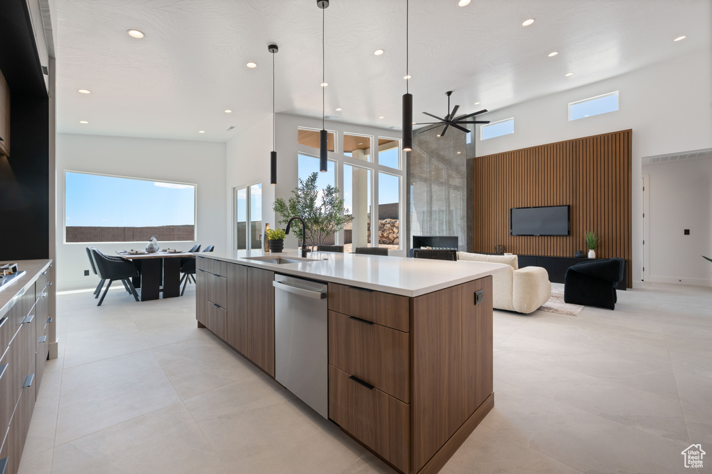 Kitchen with modern cabinets, a sink, a towering ceiling, dishwasher, and a spacious island