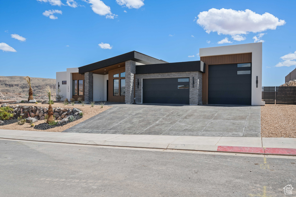Modern home featuring an attached garage, driveway, and stucco siding