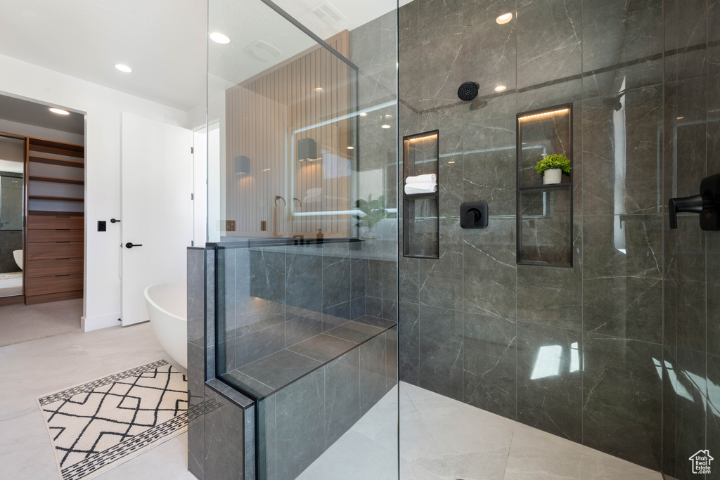 Bathroom with a freestanding bath, a walk in shower, and recessed lighting