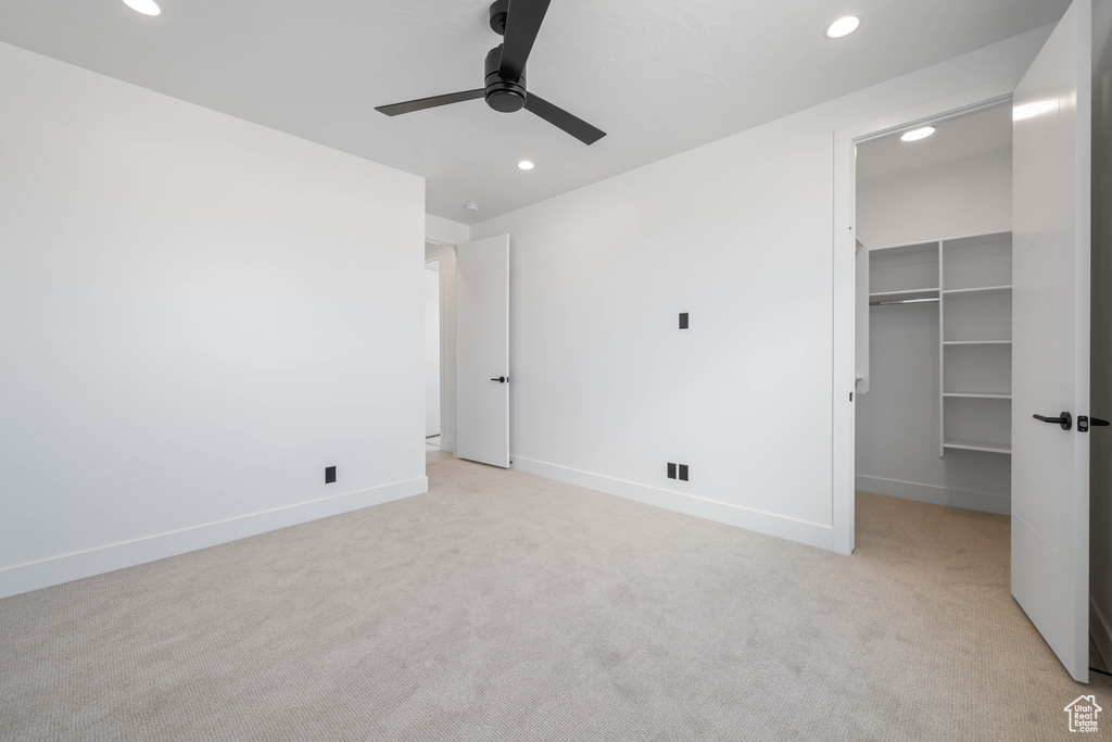 Unfurnished bedroom featuring recessed lighting, light colored carpet, a spacious closet, baseboards, and a closet