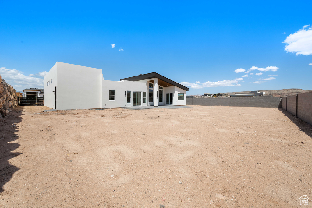 Back of property featuring a fenced backyard, stucco siding, and a patio