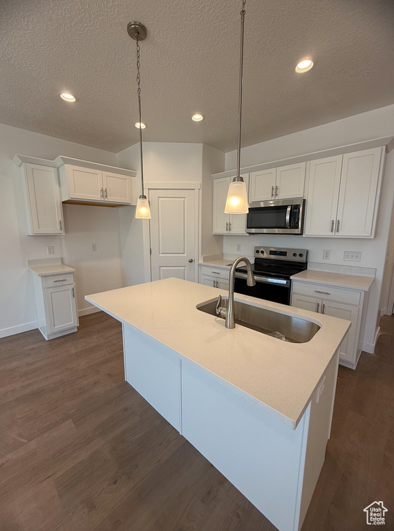 Kitchen featuring appliances with stainless steel finishes, a sink, white cabinetry, baseboards, and a textured ceiling
