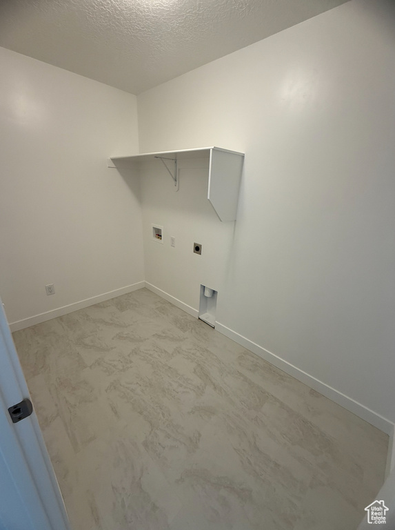 Washroom featuring washer hookup, baseboards, electric dryer hookup, and a textured ceiling