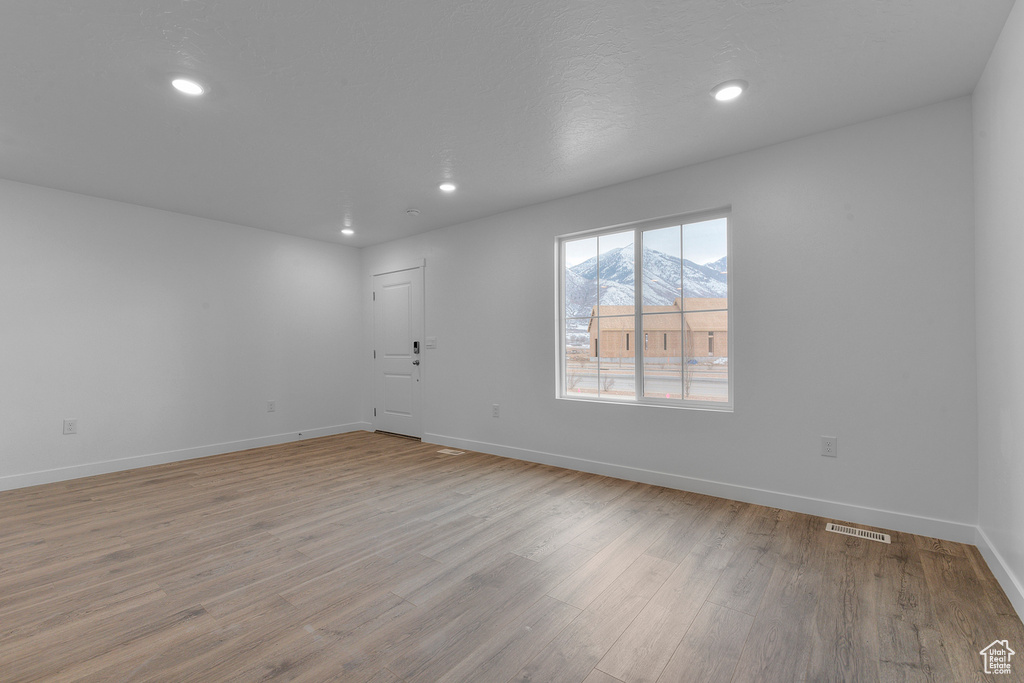 Spare room featuring light wood-type flooring, baseboards, and recessed lighting