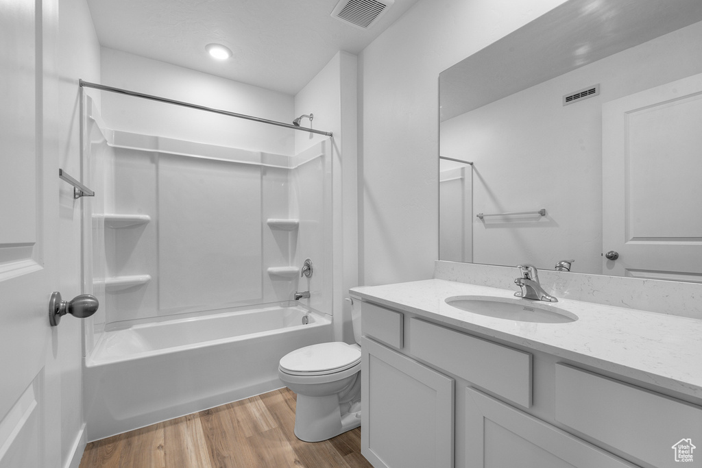 Full bath with wood finished floors, toilet, shower / washtub combination, and vanity