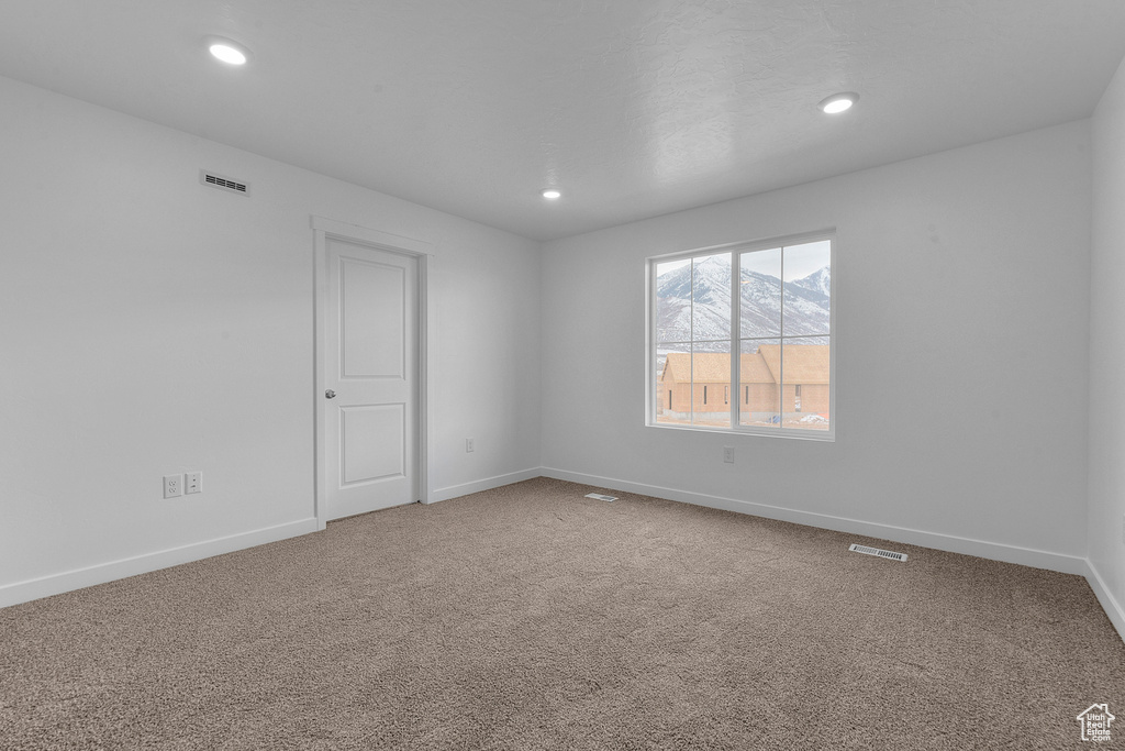 Spare room featuring carpet flooring, baseboards, and recessed lighting