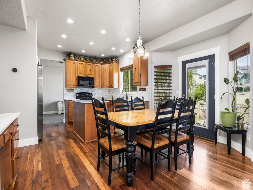 Dining room with recessed lighting, dark wood-style floors, healthy amount of natural light, and baseboards