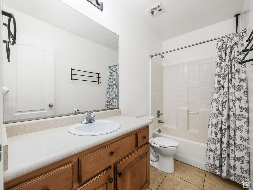 Full bathroom featuring tile patterned flooring, vanity, toilet, and shower / bath combo